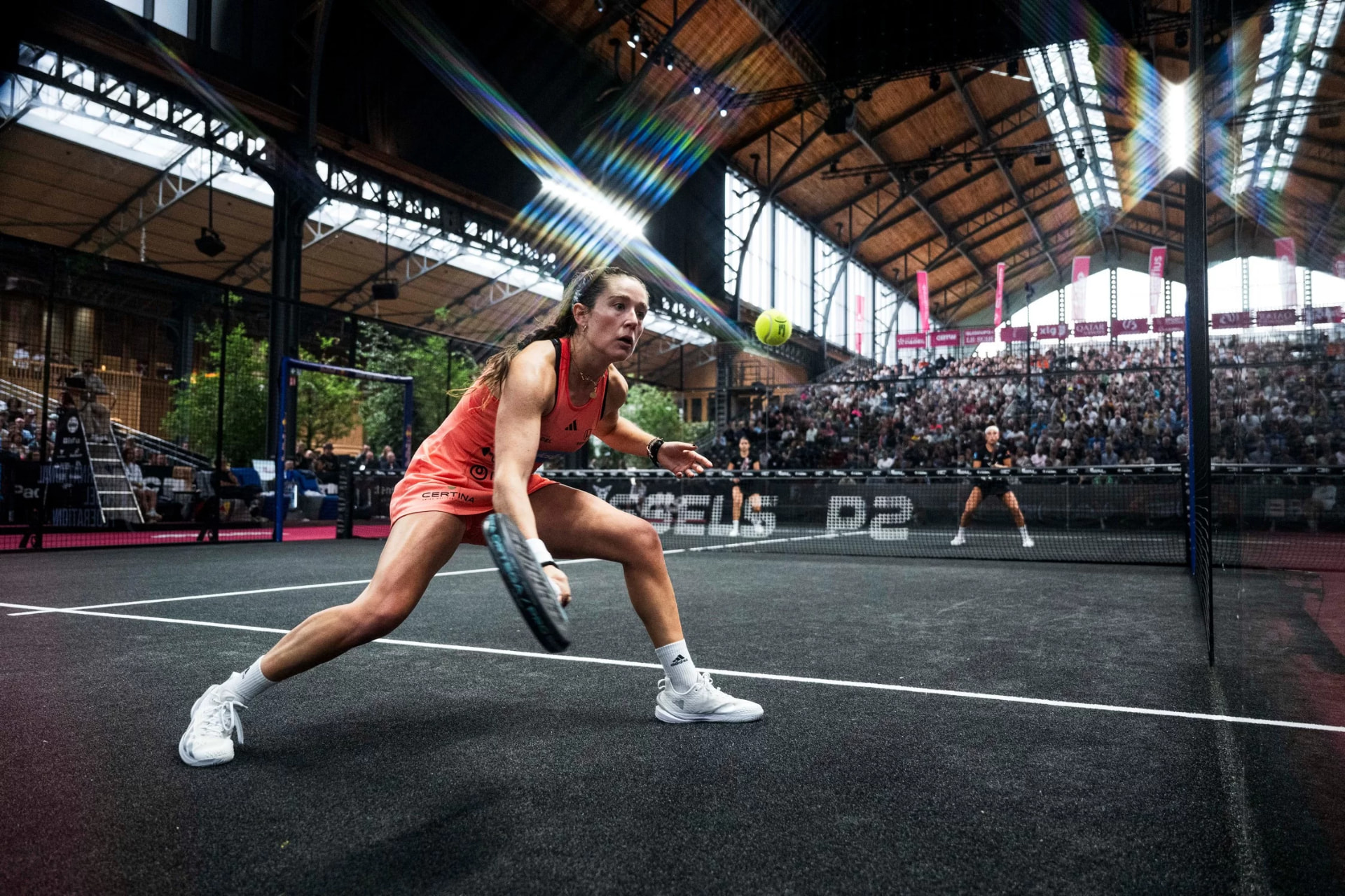 Giocatrice in allungo durante un match di padel