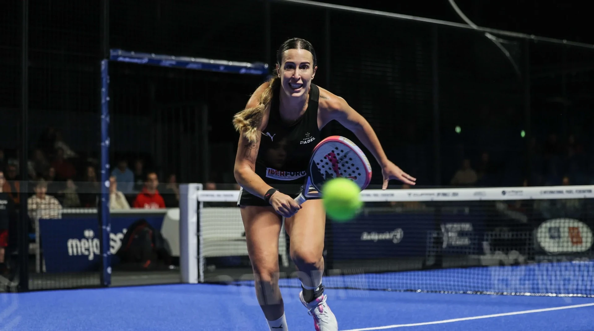 Giocatrice colpisce la pallina durante un match di padel